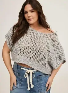 Sueter oversized y cropped de punto abierto con escote redondo y manga corta. Una prenda de diseno holgado que es ideal para quienes buscan comodidad en los brazos anchos